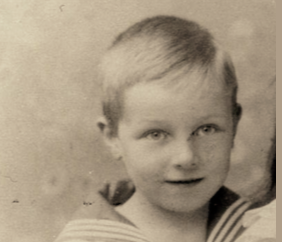 Ausschnitt aus einem Familienfoto. Eberhard Georg Wilhelm von Goerne als Kind. Das Bild zeigt einen kleinen Jungen mit blonden Haaren und hellen Augen. Er hat einen Matrosenanzug an und lächelt.